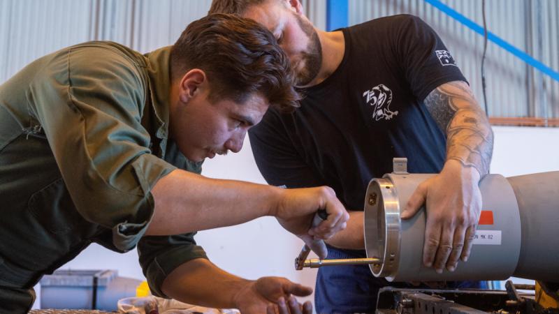 Armament fitters from RAAF's 75 Squadron and US Marine Corps Marine Fighter Attack Squadron 214 work together during Exercise Magpie Lightning. 