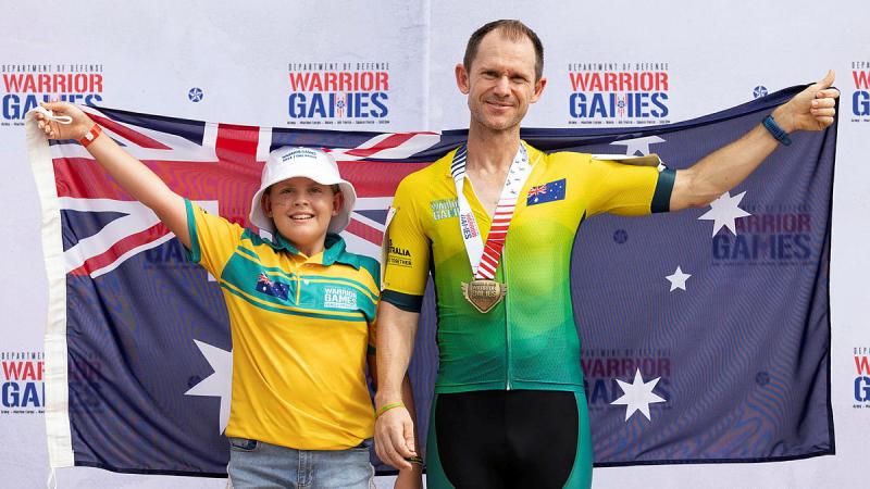 Along with his daughter Madeleine, Warrior Games competitor Adam Jackson celebrates wining gold during the cycling at the ESPN Wide World of Sports Complex, Florida USA.  