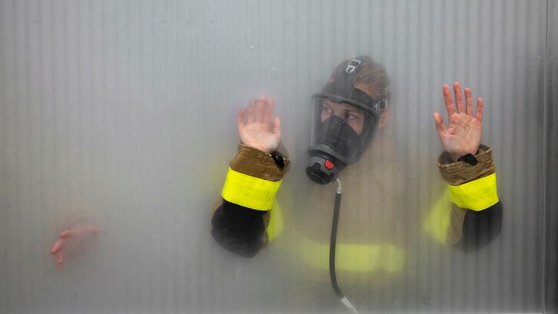 An Essendon player conducts a smoke walk during pre-season training camp at the RAN School of Survivability and Ship Safety, HMAS Cerberus.