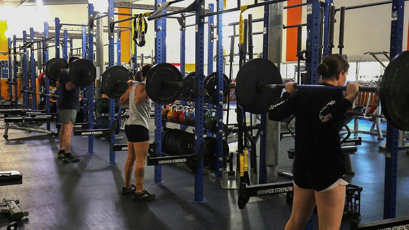 Air Force movements personnel prepare to perform back squats during a MOVFIT session at the 27 Squadron Human Performance Centre, RAAF Base Townsville.