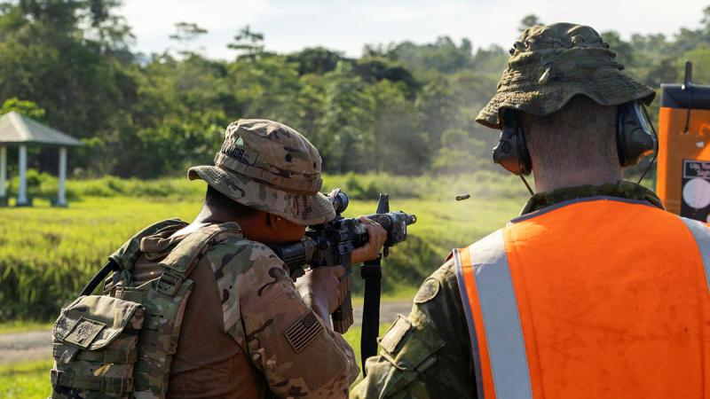 Australian soldier from Rifle Company Butterworth 144 gives feedback to a soldier from the US Army during close combat shooting drills as part of Exercise Keris Strike in Malaysia. 