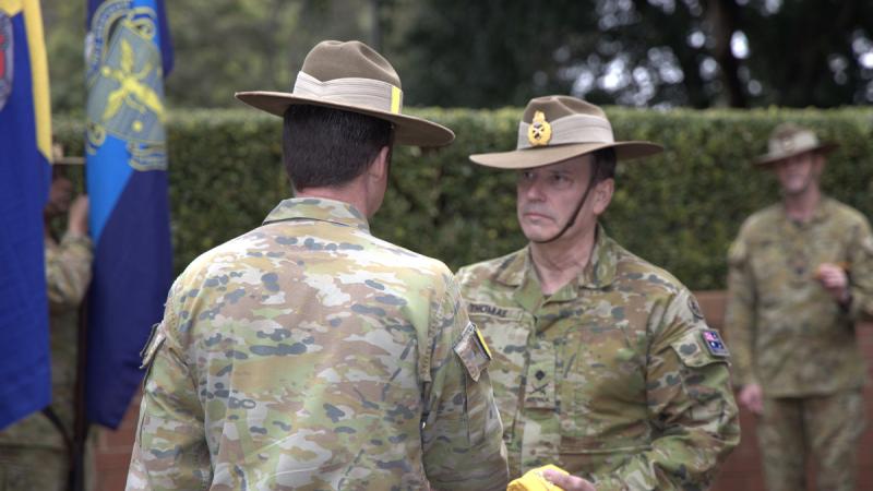 Commander 2nd (Australian) Division, Major General David Thomae, AM hands Commander 8th Brigade, Brigadier Arran Hassell, CSC the Brigade pennant at the 8th Brigade Transfer of Authority ceremony at Randwick Barracks, Sydney.