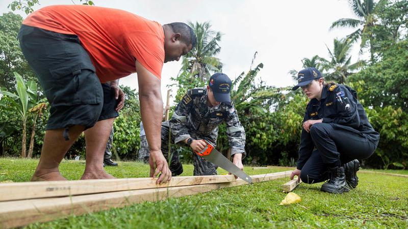 Midshipman Mitchell Nield, centre, and Royal New Zealand Navy Sub Lieutenant Engineering Officer Agnieske Keenan, right, from HMAS Choules help locals build a greenhouse at Tuana’i Seventh Day Adventist Church.