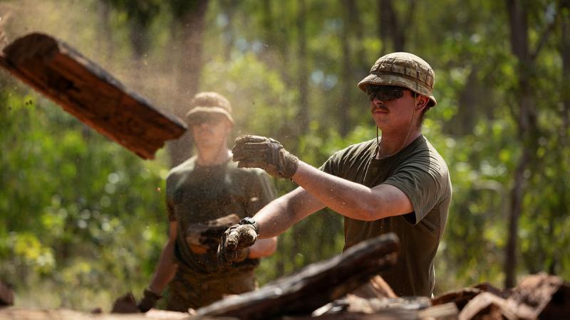 Australian Army soldier Sapper Jack Henderson, from 1st Combat Engineer Regiment, throws wood on a pile for the Garma Festival during Exercise Predator's Run in Nhulunbuy, NT. 