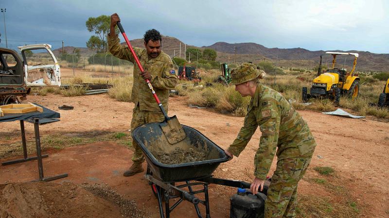 Private Luke Kennedy and Captain Debra Johnson mixing cement to create tiles for the Amata Anangu School in remote north-western South Australia.