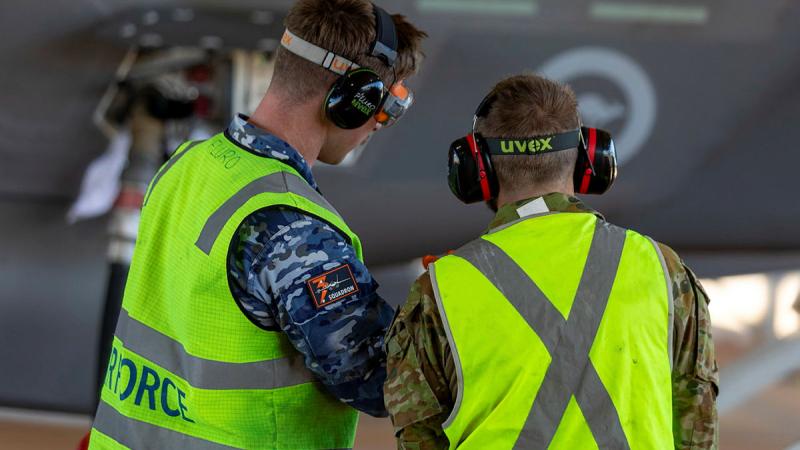 Two ground crew from 13 Squadron monitor refuelling of an F-35A Lightning II.