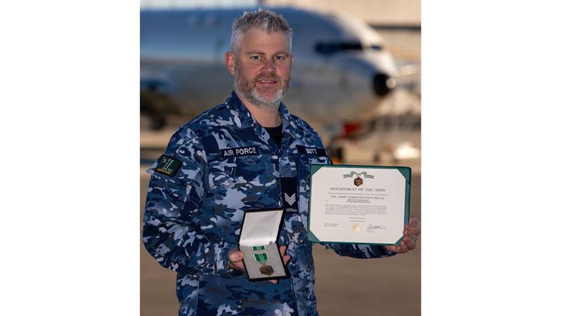 Sergeant Nathan Butt holds his US Army Commendation Certificate and Medal, which he earned for exemplary technical liaison work while on Exercise RIMPAC 2022.