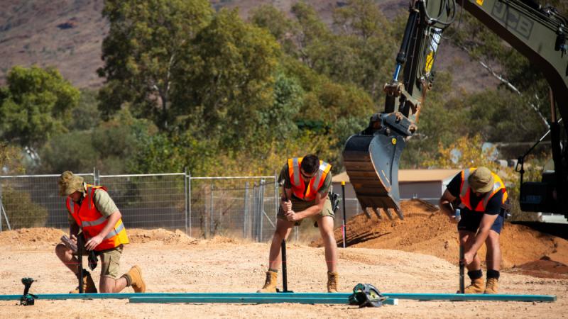 Army soldiers and an Air Force aviator build formwork at the construction site for the self-contained service provider accommodation during the 2024 Army Aboriginal Community Assistance Programme in Amata, South Australia.