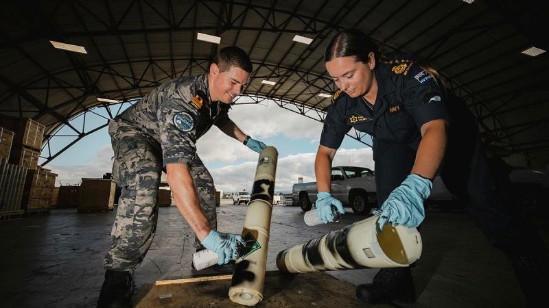 Navy Lieutenant David Gouge and Royal New Zealand Navy Acting Chief Petty Officer Kendra Young dispose of equipment during Exercise Rim of the Pacific, in Hawaii. 