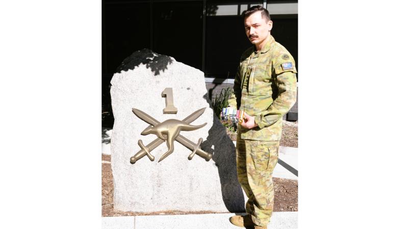  Army Captain Blake Parbery holds his grandfather Gordon Wells' service medals, outside Headquarters 1st (Australian) Division, Gallipoli Barrack, Enoggera, QLD.