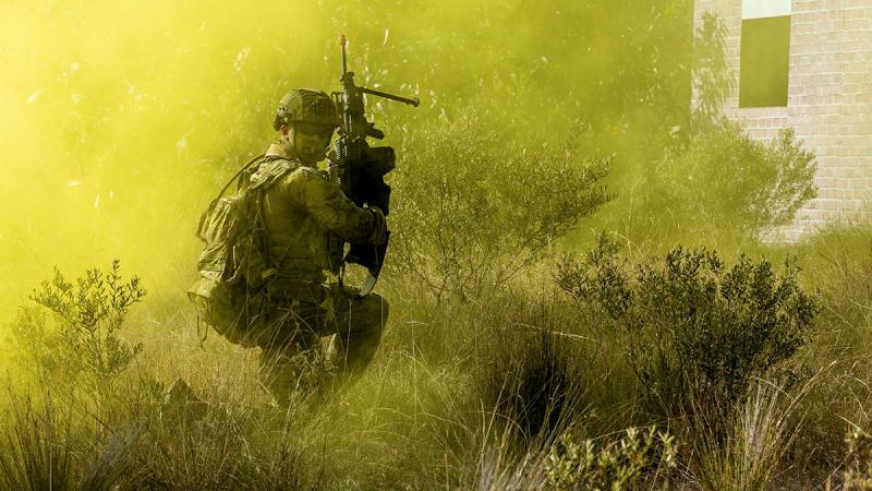 A soldier from 11th Brigade checks on his mates as he advances forward during an assault on an 'enemy' defensive position at Cowley Beach training area in northern Queensland. 