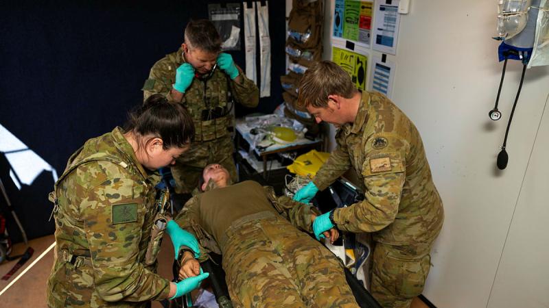 Corporal Timothy Rymill, right, and other Army medical personnel from 1st Health Battalion triage a simulated patient inside the Role 1 treatment facility at RAAF Base Curtin, WA, during Exercise Austral Shield. 