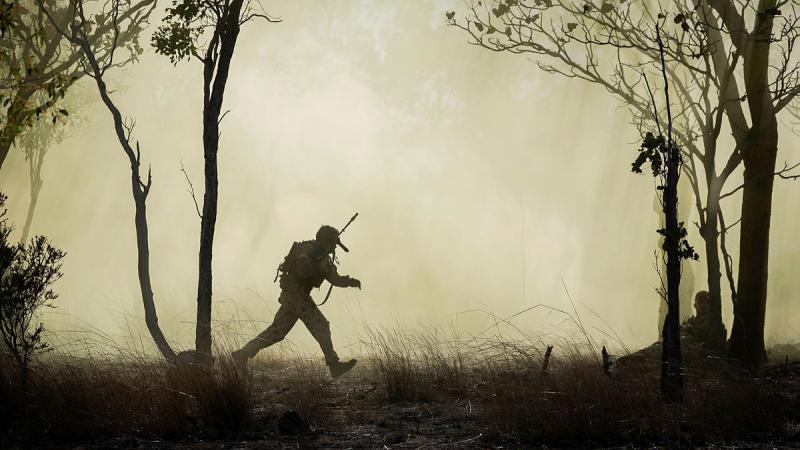 An enemy combatant bounds away from 1st Brigade and the Armed Forces of the Philippines as they clear an objective at the Bradshaw training area during Exercise Predator's Run.