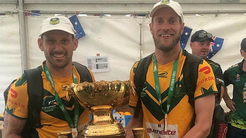 Leading Seaman Stephen Holmes, right, holds the Touch Football World Cup trophy with teammate Luke Simmons after their victory in the men’s 30s division in Nottingham, England.
