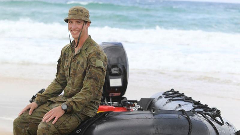 Private Alex Blantz from the 10th Force Support Battalion sits on an F470 Zodiac small boat at Rainbow Beach, Queensland.