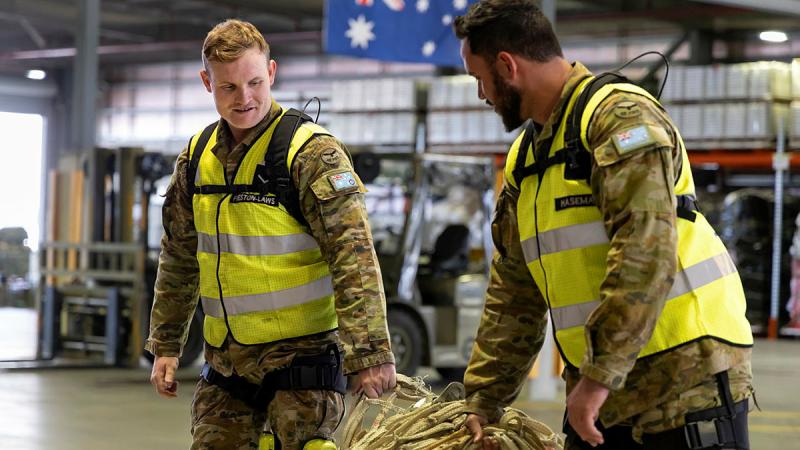 Leading Aircraftman Brandan Preston-Laws (left) and Luke Hasemann from No 23 Squadron move equipment around, while testing out the Apex 2 exoskeleton at RAAF Base Amberley. 