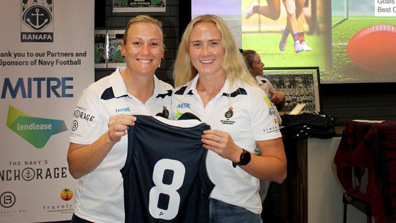 Able Seaman Meg Buchanan, right, receives her Navy jersey from ADF All Stars head coach Lieutenant Commander Elisabeth Quinn.