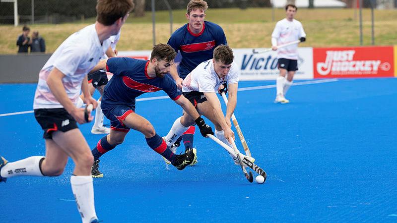 Flight Lieutenant Andrew Stewart fights for the ball from the South Australian Men's Hockey team.