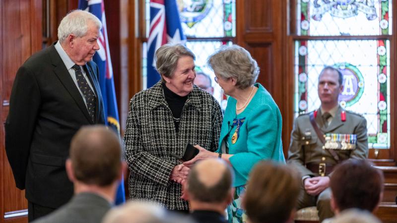 Governor of South Australia, Her Excellency Frances Adamson (right), presents Elizabeth Buchanan with a Medal for Gallantry, which was posthumously awarded to her father, the late Pilot Officer Warren Frank Cowan, for his actions in hazardous circumstances on 22 July 1942.