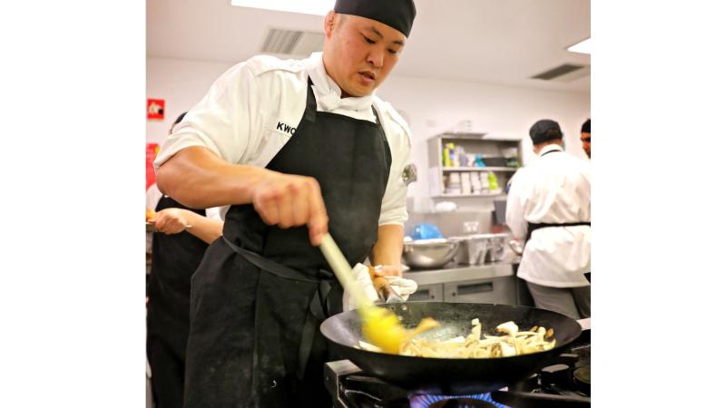 Graduating Australian Defence Force Cook Seaman Buyngchun Kwon cooking in the galley during his graduation day at the Zest Restaurant in Holmesglen TAFE, Glen Waverley, Victoria.
