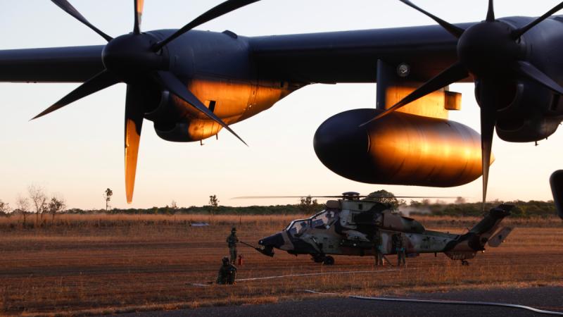 An Army ARH Tiger helicopter from 1st Aviation Regiment is refuelled from an Air Force C-130J Hercules by ground maintenance personnel in a remote region of the Northern Territory during Exercise Diamond Storm. 