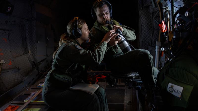 35 Squadron Loadmasters Corporal Deniele Oehm (l) and Corporal Peter Fowler review images of fishing vessels on board a C-27J Spartan aircraft, during Operation Island Chief 2024.