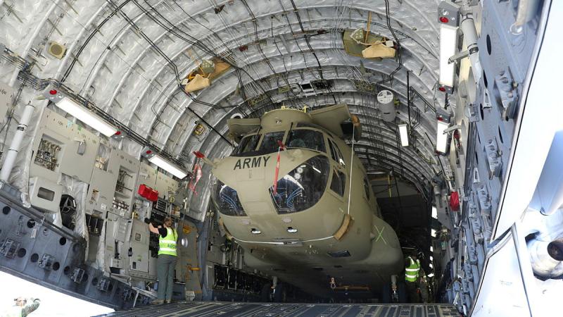 A CH-47F Chinook helicopter is loaded inside a Royal Australian Air Force C-17 Globemaster III as part of recent strategic sir deployment training by 5th Aviation Regiment at RAAF Base Townsville.