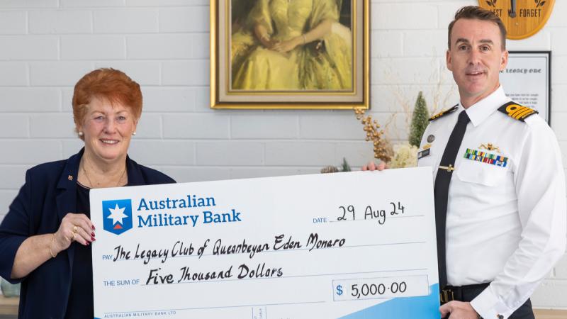 Commanding Officer HMAS Harman Royal Australian Navy Commander Glyn Hunter presents Legacy Club of Queanbeyan-Eden-Monaro President Legatee Suzanne McInnes with a cheque during a morning tea at the Legacy Club of Queanbeyan-Eden-Monaro, NSW.