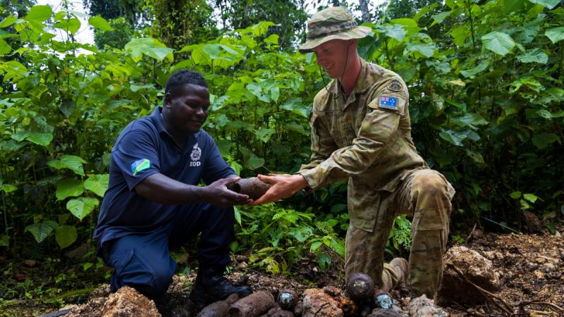 Australian Army Corporal Solomon Boyd and Royal Solomon Islands Police Force officer Tusa consolidate Explosive remnants of war (ERW) located in the Solomon Islands during Operation Render Safe, Munda, Solomon Islands.