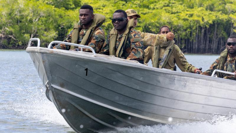 Vanuatu Mobile Force police officer Private Carlen Kaldtapas (left) and Lance Corporal Gino Keneth ride in the bow of an Australian Army boat during a handling demonstration in Trinity Inlet near Cairns, Queensland.