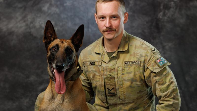 Air Force military working dog handler, Leading Aircraftman James Reid from 1 Security Forces Squadron and retired military working dog Drak, RAAF Base Williamtown.