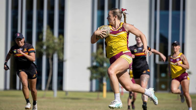 Aircraftwoman Sophia Collins charges through a gap in the defence during the ADF Touch Football Nationals held at Randwick Barracks, in NSW. 