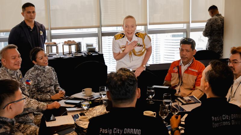 Captain Emma McDonald-Kerr talks with participants of the humanitarian assistance and disaster relief tabletop Exercise as part of Indo-Pacific Endeavour 2024 in the Philippines.