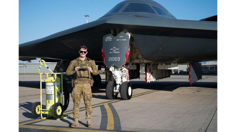 Leading Aircraftman Blake O'Brien with a United States Air Force B-2 Spirit bomber on the RAAF Base Amberley flight line.