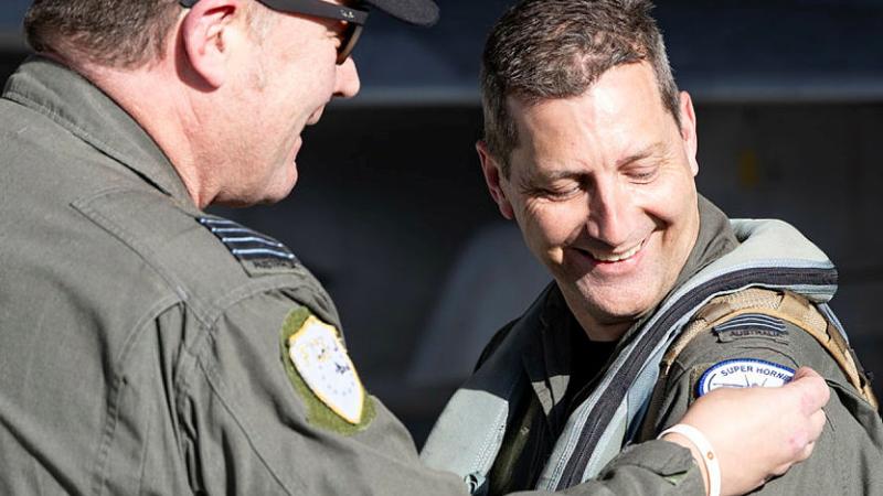 Squadron Leader Jason Gamlin, right, is presented with his 4000th Hornet hour by Officer Commanding 82 Wing, Group Captain Paul Jarvis, at RAAF Base Amberley. 