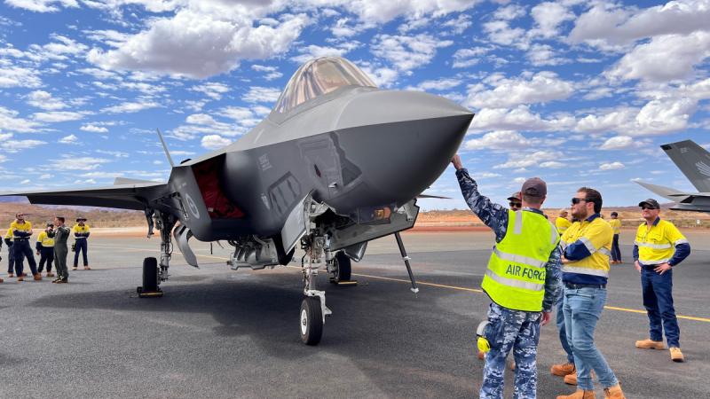 Aircraftman Nicholas Thorpe, of 25 Squadron, and Squadron Leader James Wheeler, of 3 Squadron, speak with Eliwana mine staff during a visit to Eliwana airport in the Pilbara region of WA.