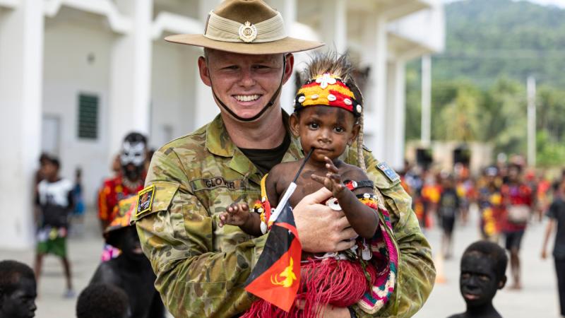 Lance Corporal Bayley Glover with Papua New Guinean locals celebrate the 49th Independence Day at King Charles Oval at Wewak, Papua New Guinea.