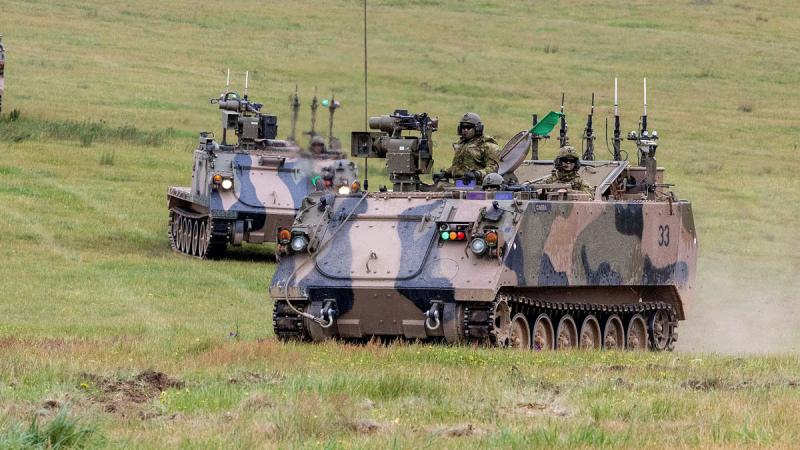 Optionally crewed combat vehicle move across the range as part of the Land Autonomous Systems & Teaming–Demonstration at Puckapunyal Military area.