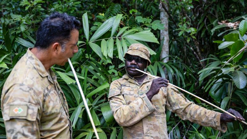  Army soldiers from the Northwest Mobile Force, Corporal Carl Murkun (R) and Sergeant Jeremy Kee, chow down on some bush tucker of young palm hearts during a cultural immersion near Gapuwiyak in Arnhem Land.