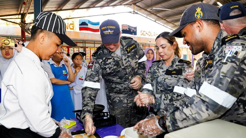 From left, Able Seaman Ben Champley, Leading Seaman Joanne Hill and Leading Seaman Rocky Ahwang help to make Anzac biscuits during a visit to Sekolah Menengah Kebangsaan Sanzac school in Kota Kinabalu, Malaysia. 