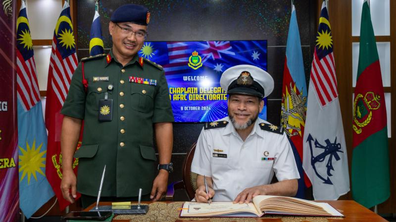 Royal Australian Navy Chaplain Mogamat Majidih Essa signs the visitor register alongside the Malaysian Armed Forces' Brigadier General HJ Mohd Hamzah Bin Adam at the Malaysian Armed Forces Religious Corps Directorate during Indo- Pacific Endeavour, Kuala Lumpur, Malaysia.