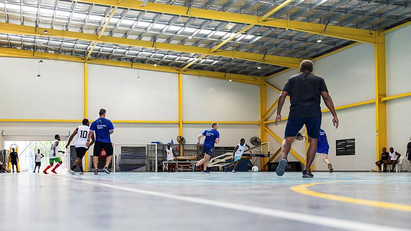 Members of the Royal Solomon Islands Police Force Explosive Ordnance Disposal Department and the ADF participate in a friendly match of indoor soccer at Solomon Islands National Institute of Sport, Honiara, Solomon Islands. 