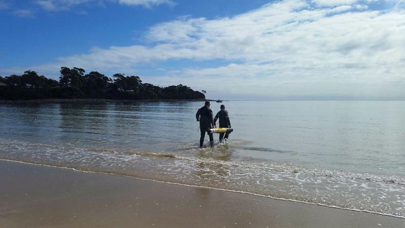 Students from Navy's Mine Warfare Faculty wade out in the water as part of training in Tasmania.