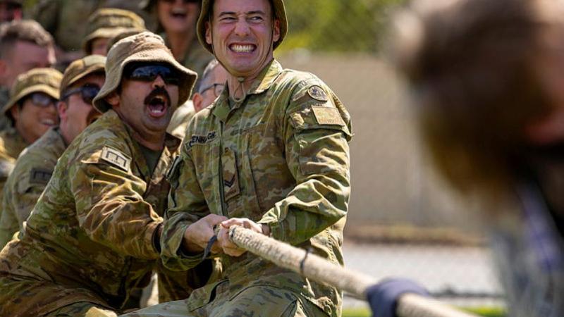 Soldiers take part in a tug-of-war with children.