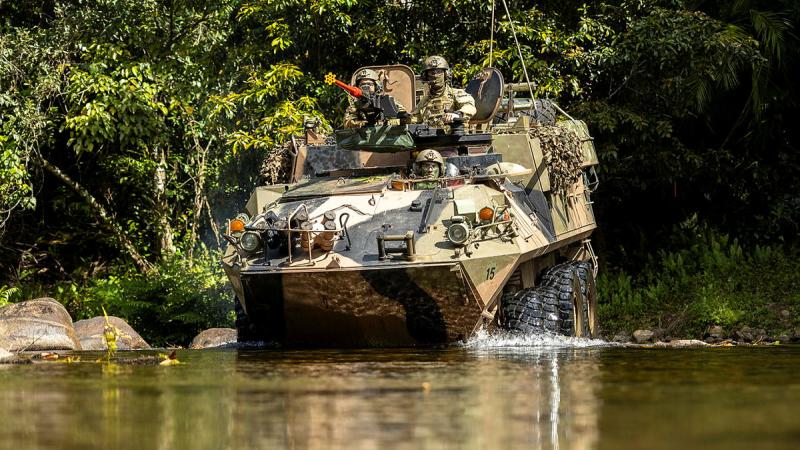 An Army light armoured vehicle crosses a river in Tully Training Area.