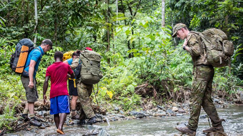 Australian Army Jonathan Church Good Soldiering Award ambassador recipient Private Caleb Walker crosses a river while trecking Lark Force’s withdrawal route between the villages of Dodul and Maranagi in East New Britain, PNG.