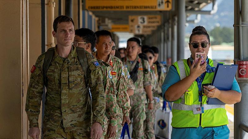 Australian Army soldier Private Nicholas Stainer leads a group of People’s Army of Vietnam United Nations peacekeepers from the terminal at Seychelles International Airport during a strategic airlift.