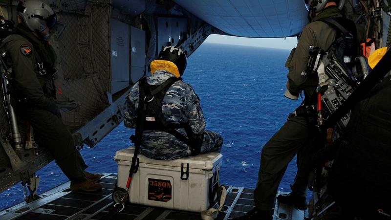 From left, Warrant Officer Steven Burrows, Leading Aircraftman Kurt Lewis and Sergeant Ben Richardson prepare to take photos of marine traffic during a ramp ride on board a C-27J Spartan during Operation Kuru Kuru, Fiji. 