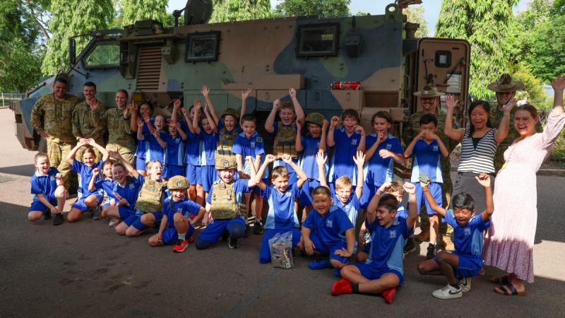 Students at Stuart Park Primary School gather in front of a Bushmaster protected mobility vehicle from the 8th/12th Regiment, Royal Australian Artillery, in Darwin.
