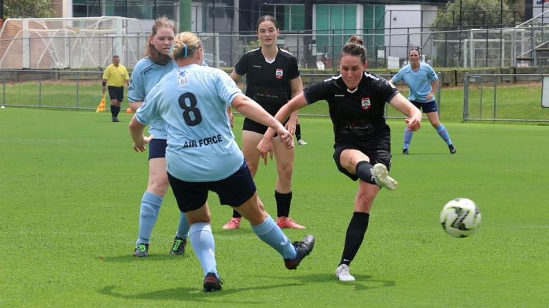 An Army player avoids an Air Force defender during the inaugural Australian Army versus Royal Australian Air Force Remembrance Day match at Perry Park, Brisbane.